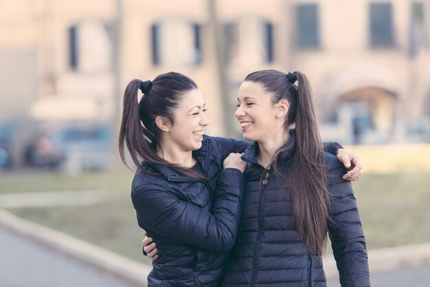 Femininos gêmeos jogando juntos e desfrutar de pegar cavalinho