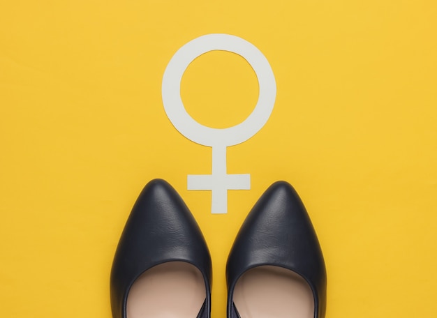 Foto feminismus weibliches geschlechtssymbol hohe absatzschuhe auf gelbem hintergrund