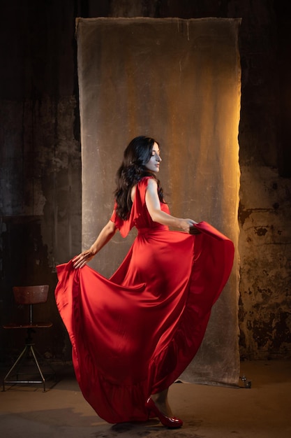 Foto femme fatale em vestido vermelho uma bruneta atraente em um vestido elegante