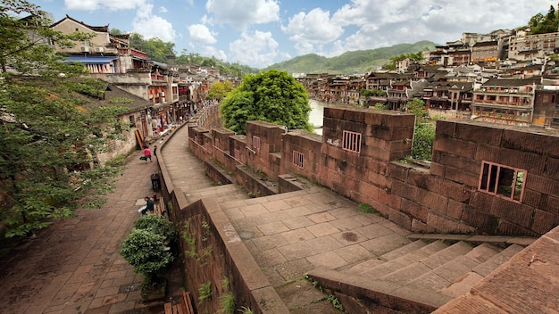 Fenghuang Hunan / China - 20 de junho de 2017: os turistas caminham ao longo da margem do rio na cidade velha de Phoenix, ou no condado de Fenghuang, um condado da província de Hunan, na China