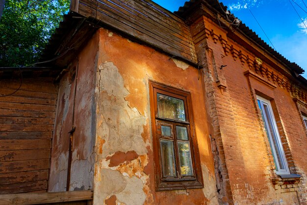 Fenster eines alten Vintage-Hauses am Nachmittag an einem sonnigen Tag. Architektur der Provinzstadt der Ukraine. Sowjetunion Alter Gebäude UdSSR