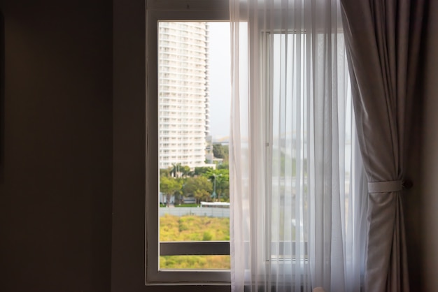 Fenster mit Vorhängen oder Vorhang blind durch das Bett, Innendekorationskonzept.