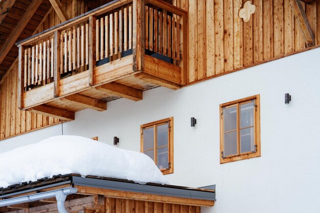 Fenster und Balkon der Hausarchitektur im verschneiten Winter im Dorf Bad Goisern bei Hallstatt in Oberösterreich. Reihenhausimmobilien und Wohngebäude.