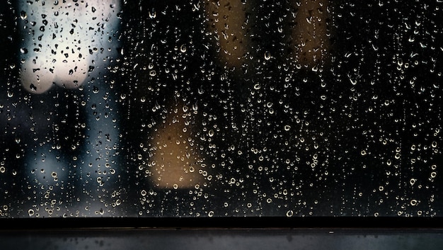 Fenster und Regen fallen an einem regnerischen Tag in Eigentumswohnungen oder Apartmentzimmer