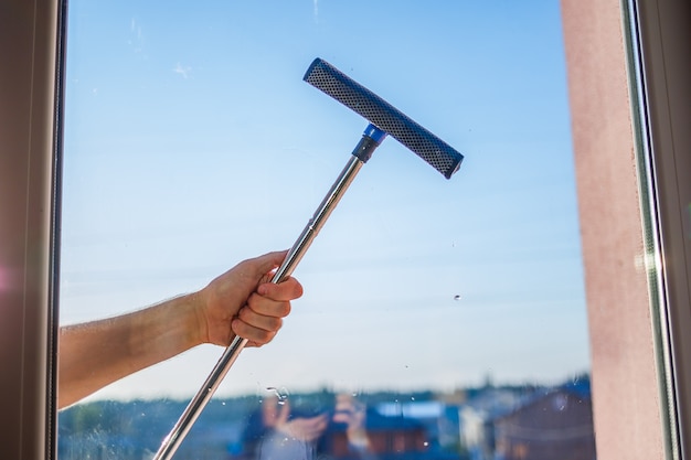 Foto fensterreinigung in hochhäusern, häuser mit einer bürste. reinigungsbürste für fenster. großes fenster in einem mehrstöckigen gebäude, reinigungsservice. staubentfernung und glasreinigung.