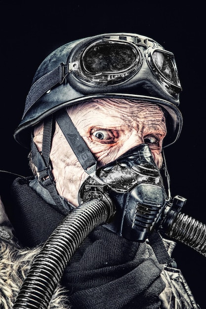 Feo rostro de soldado nazi futurista con máscara de gas y casco de acero. Piel quemada por llama atómica