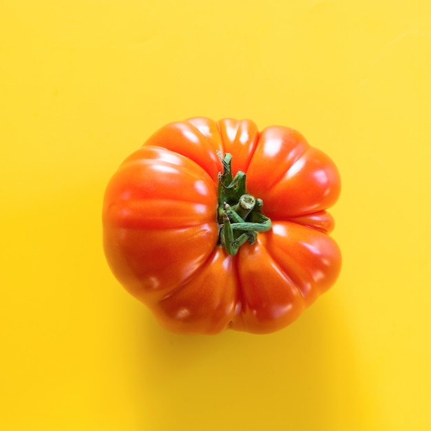 Foto feo un tomate orgánico en amarillo.