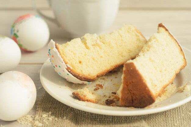 Feriado de Páscoa pequeno-almoço de páscoa fatias de bolo de Páscua doce em um prato e ovos de Pásqua em um fundo de madeira leve