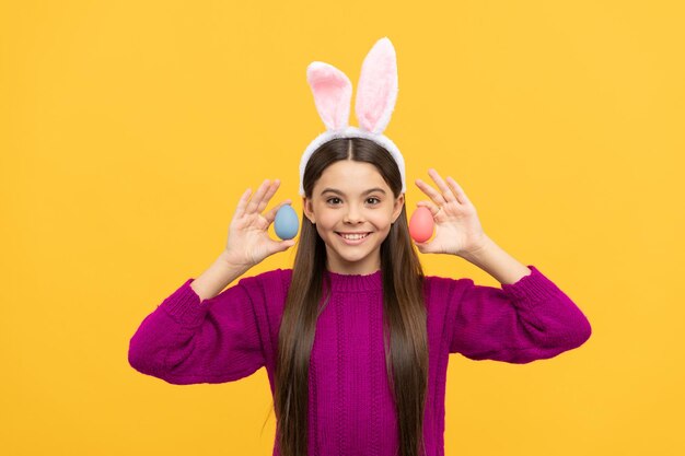 Foto feriado de primavera de páscoa adolescente feliz vestindo orelhas de coelho feliz páscoa infância felicidade criança em traje de coelho segure ovos pintados tempo para caçar ovos criança adorável usando orelhas de lebre engraçadas