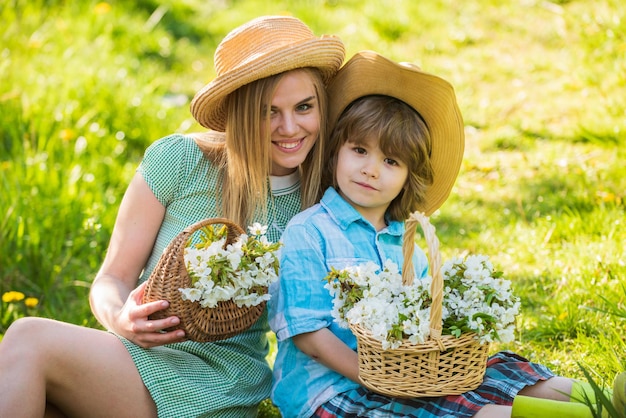 Feriado de primavera Flores silvestres no campo Felicidade da maternidade Família Cowboy coletando flores em cestas Adorável fundo da natureza familiar Boas festas Mãe e filho fofo usam chapéus Fazenda da família