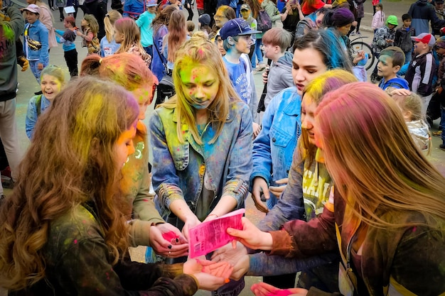 Feriado indiano de Holi Jovens na multidão colocam pó colorido nas mãos e jogam para cima