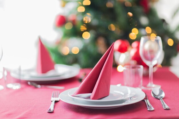 Feriados, celebração e conceito de casa - close-up da sala com árvore de natal e mesa decorada