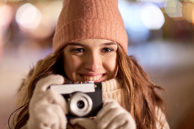 feriados, fotografia e conceito de pessoas - close de bela jovem feliz com câmera no Natal