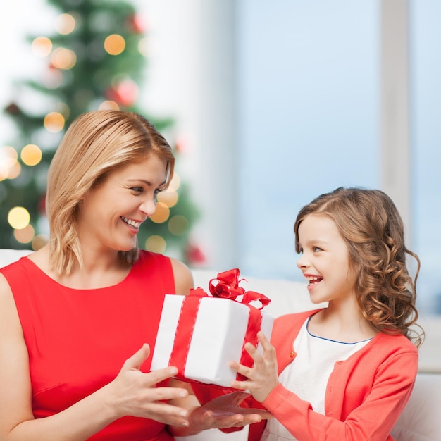 feriados, presentes, natal, conceito de natal - feliz menina mãe e filho com caixa de presente