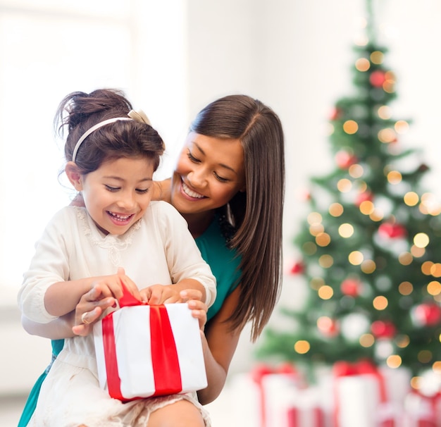 feriados, presentes, natal, natal, conceito de aniversário - mãe feliz e menina criança com caixa de presente