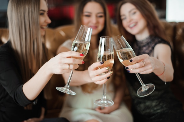 Feriados, vida noturna, festa de solteira e conceito dos povos - mulheres de sorriso com vidros do champanhe.