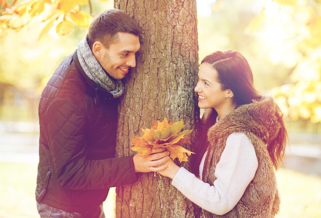 férias, amor, viagens, turismo, relacionamento e conceito de namoro - casal romântico brincando no parque de outono