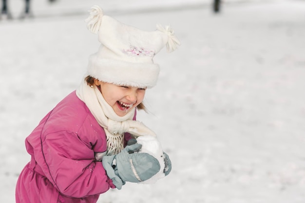 Férias ativas de inverno infância feliz inverno andando no parque criança rindo brincando com neve