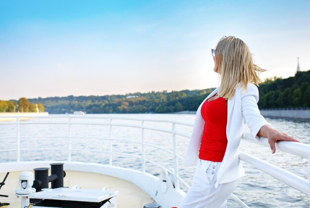 Férias de barco de cruzeiro jovem mulher bonita em óculos de sol relaxando no convés apreciando a vista do barco Feliz turista casual no destino de férias