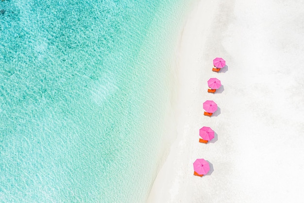 Férias de praia aérea de luxo, fundo de férias de viagens de verão. Espreguiçadeiras, cadeiras com guarda-chuva rosa