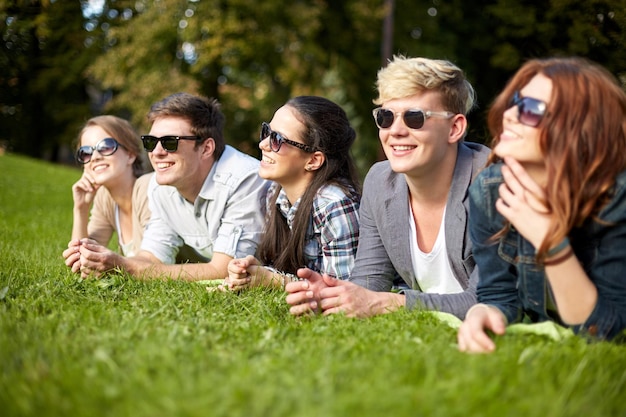 Férias de verão, amizade, lazer e conceito adolescente - grupo de estudantes ou adolescentes saindo no campus ou parque