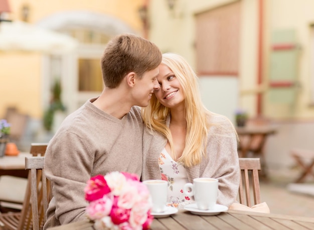 férias de verão, amor, viagens, turismo, relacionamento e conceito de namoro - romântico casal feliz se beijando no café