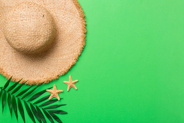 Férias de verão Conceito de verão com chapéu de palha e folha tropical Espaço de cópia de vista superior plana