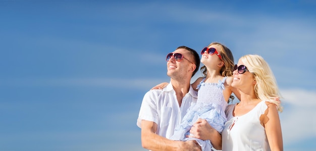 férias de verão, crianças e conceito de pessoas - família feliz com céu azul