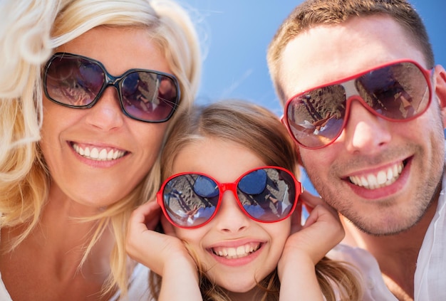 Foto férias de verão, crianças e conceito de pessoas - família feliz com céu azul