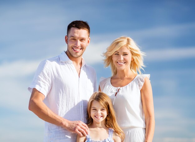 férias de verão, crianças e conceito de pessoas - família feliz com céu azul