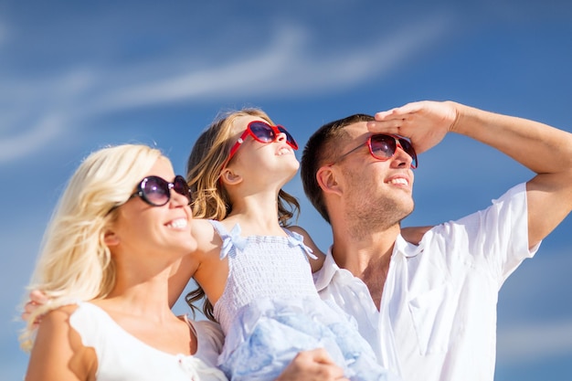 férias de verão, crianças e conceito de pessoas - família feliz com céu azul