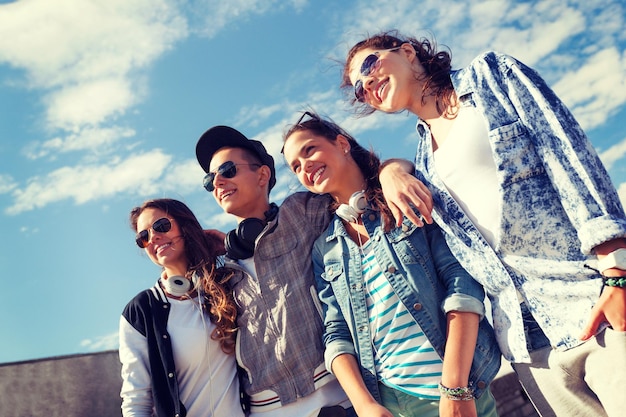 Foto férias de verão e conceito adolescente - grupo de adolescentes sorridentes em óculos de sol pendurados do lado de fora