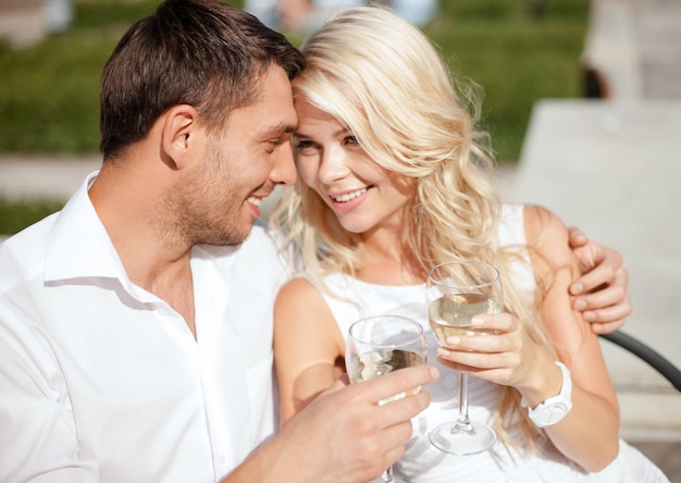 férias de verão e conceito de namoro - casal bebendo vinho em um café na cidade