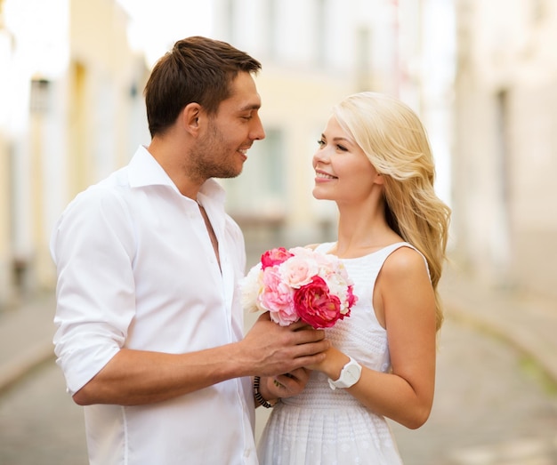 férias de verão e conceito de namoro - casal com buquê de flores na cidade