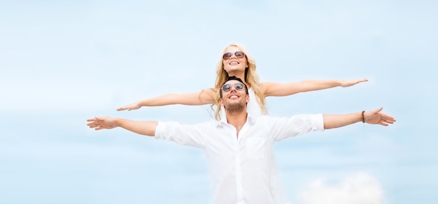 férias de verão e conceito de namoro - casal de mãos dadas à beira-mar