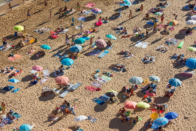 Foto férias de verão em portugal. multidão de banhistas na praia de benagil no algarve