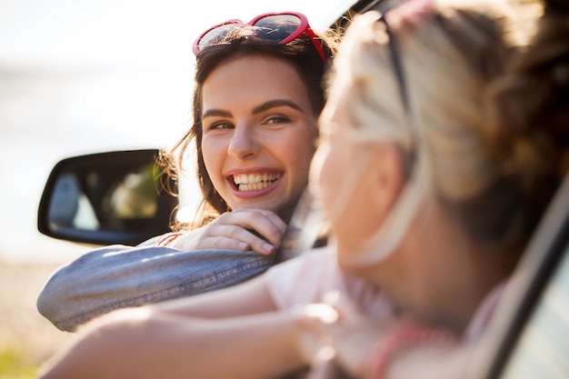 férias de verão, feriados, viagens, viagem e conceito de pessoas - adolescentes felizes ou mulheres jovens no carro à beira-mar