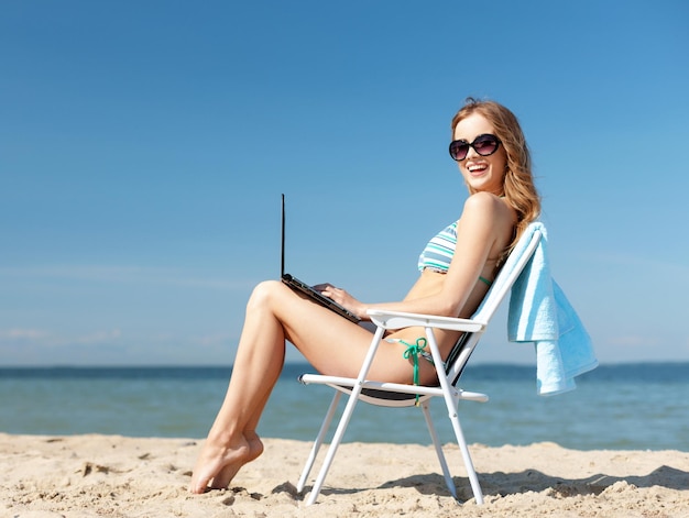 Férias de verão, férias, tecnologia e internet - garota olhando para o tablet pc na cadeira de praia