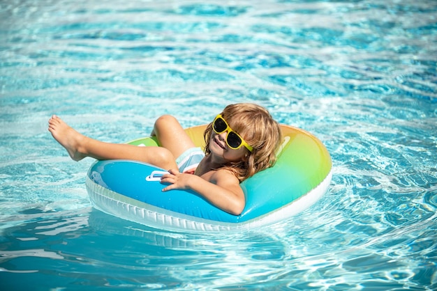 Férias de verão Fim de semana de verão para crianças Criança na piscina Garoto engraçado no círculo de borracha inflável no parque aquático