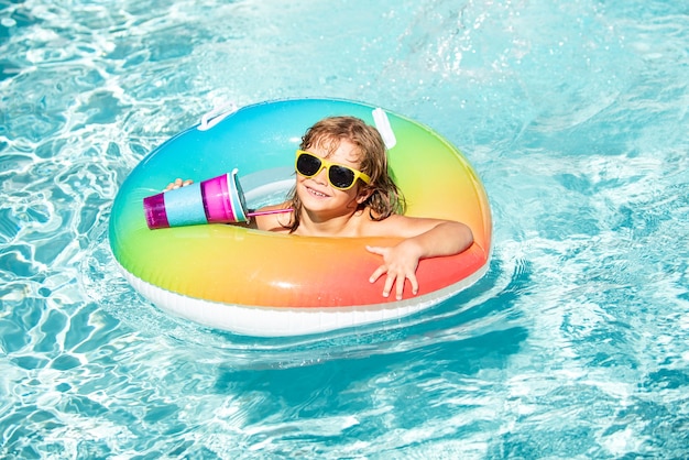 Férias de verão. garoto no parque aquático. criança beber coquetel na piscina.