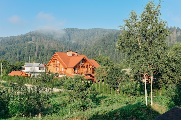 Férias de verão nas montanhas uma casa de madeira na floresta contra o fundo das montanhas