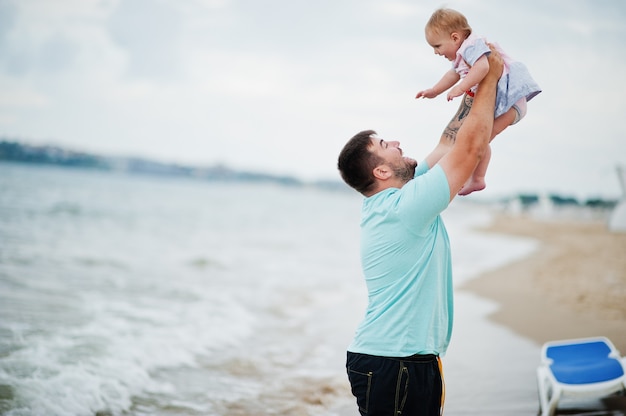 Férias de verão. pais e pessoas atividade ao ar livre com crianças. boas férias em família. pai com filha bebê na praia de areia do mar.