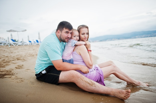 Férias de verão. Pais e pessoas atividade ao ar livre com crianças. Boas férias em família. Pai, mãe grávida, filha bebê na praia de areia do mar.