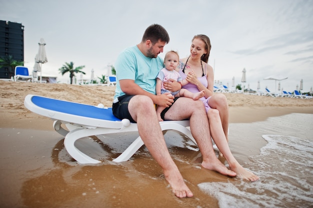 Férias de verão. Pais e pessoas atividade ao ar livre com crianças. Boas férias em família. Pai, mãe grávida, filha sentada na espreguiçadeira na praia de areia do mar.