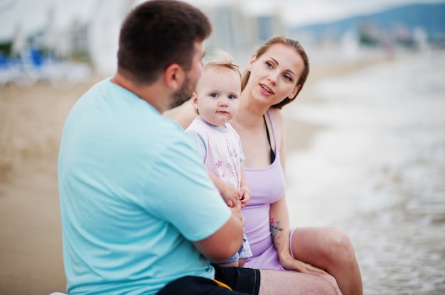 Férias de verão. Pais e pessoas atividade ao ar livre com crianças. Boas férias em família. Pai, mãe grávida, filha sentada na espreguiçadeira na praia de areia do mar.