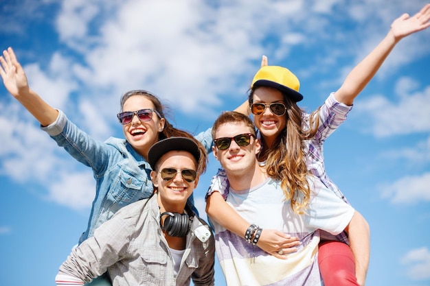 férias de verão, relacionamentos e conceito adolescente - adolescentes sorridentes em óculos de sol se divertindo lá fora