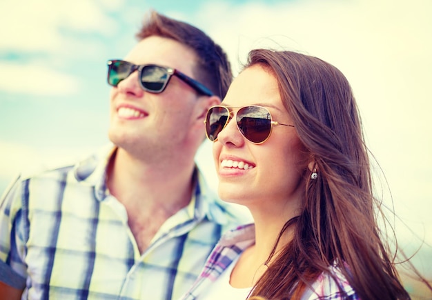 férias de verão, relacionamentos e conceito adolescente - adolescentes sorridentes em óculos de sol se divertindo lá fora