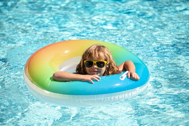 Férias de verão verão crianças fim de semana engraçado menino na piscina no círculo de borracha inflável no aqu