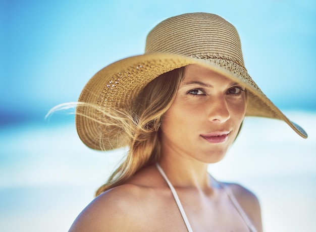 Férias de viagem e retrato de mulher na praia para o verão tropical e relaxar maquete Natureza de bem-estar e férias com rosto de turista feminina e chapéu à beira-mar para banhos de sol e paraíso