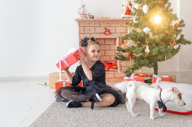 Férias e conceito de infância - Retrato de uma menina feliz e fofa com um presente de Natal